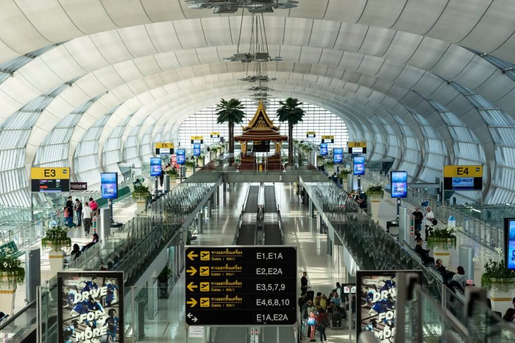 Busy arrival and departure hall in an airport with flight board