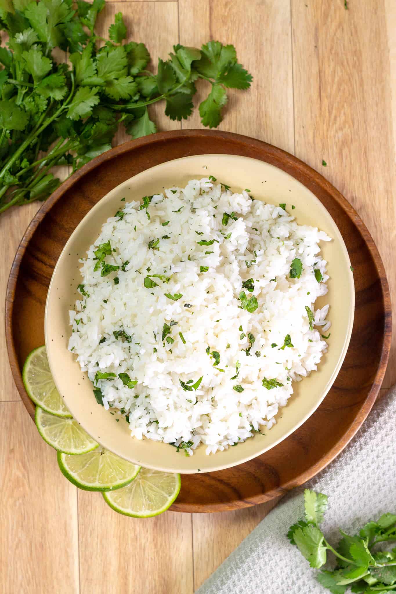 An overhead shot of cilantro lime rice surrounded by limes and cilantro.