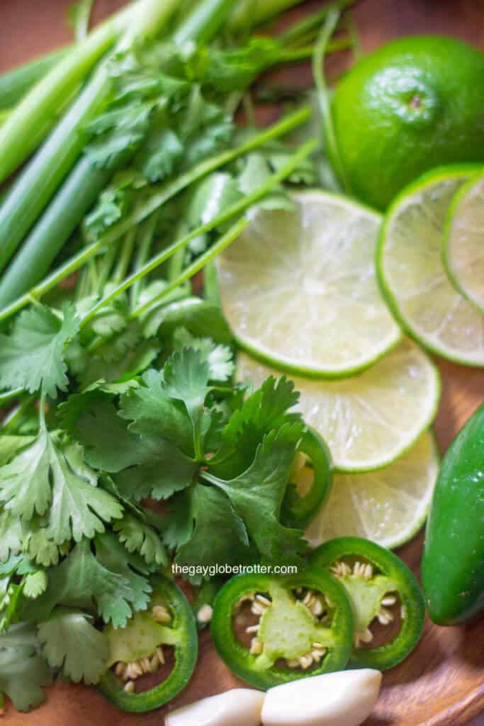 Fresh ingredients for Peruvian green sauce like cilantro, limes, green onions, and jalapenos.