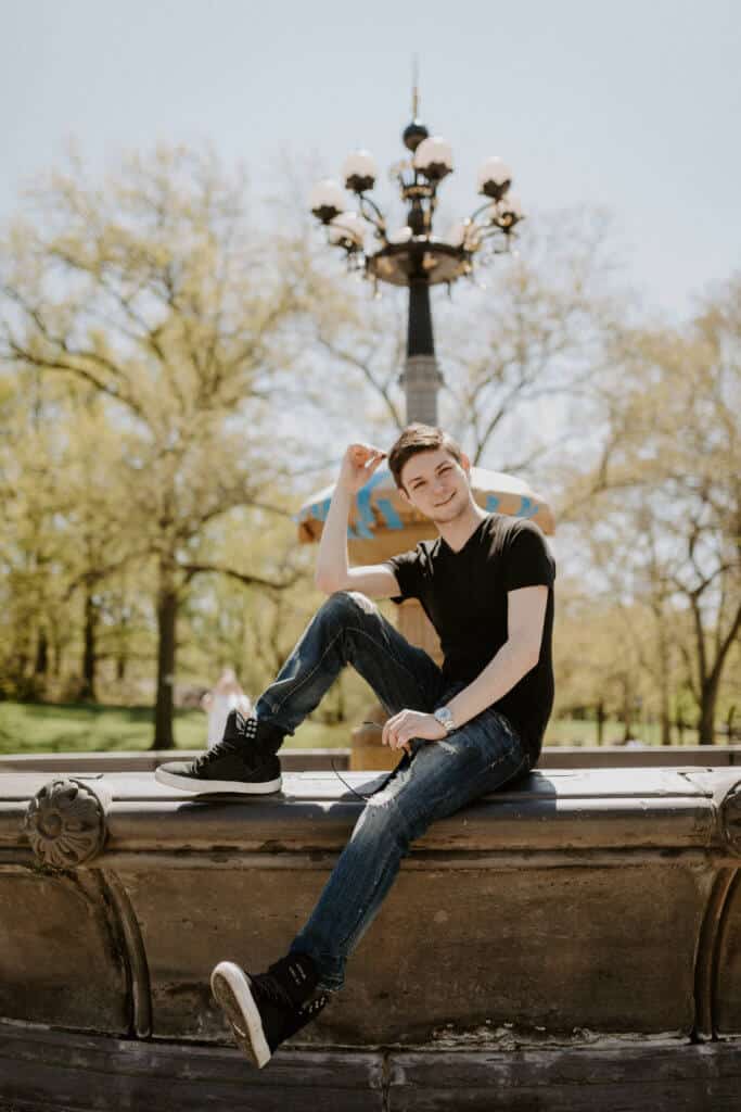 A man sitting on the Cherry Grove Fountain in Central Park.