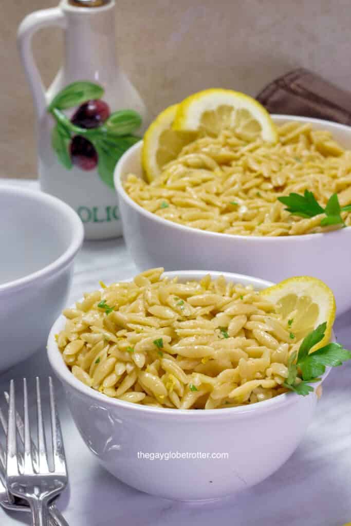 A bowl full of parmesan lemon orzo garnished with lemon.