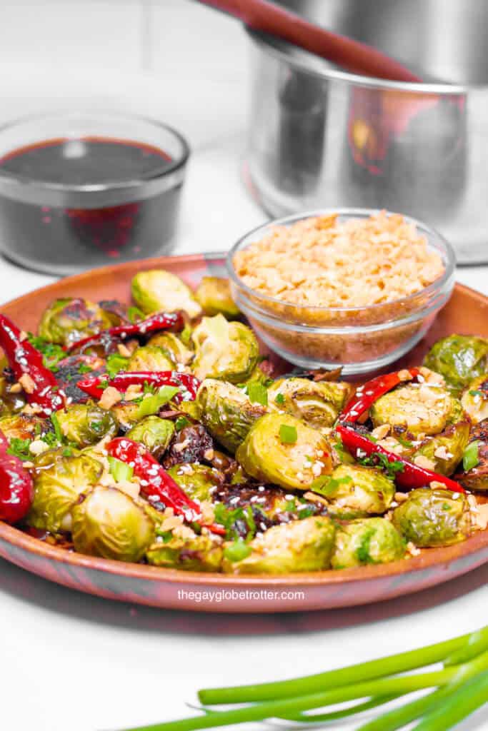 A plate of kung pao brussels sprouts with chopped peanuts.