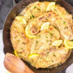 Lemon chicken piccata in a cast iron serving dish.