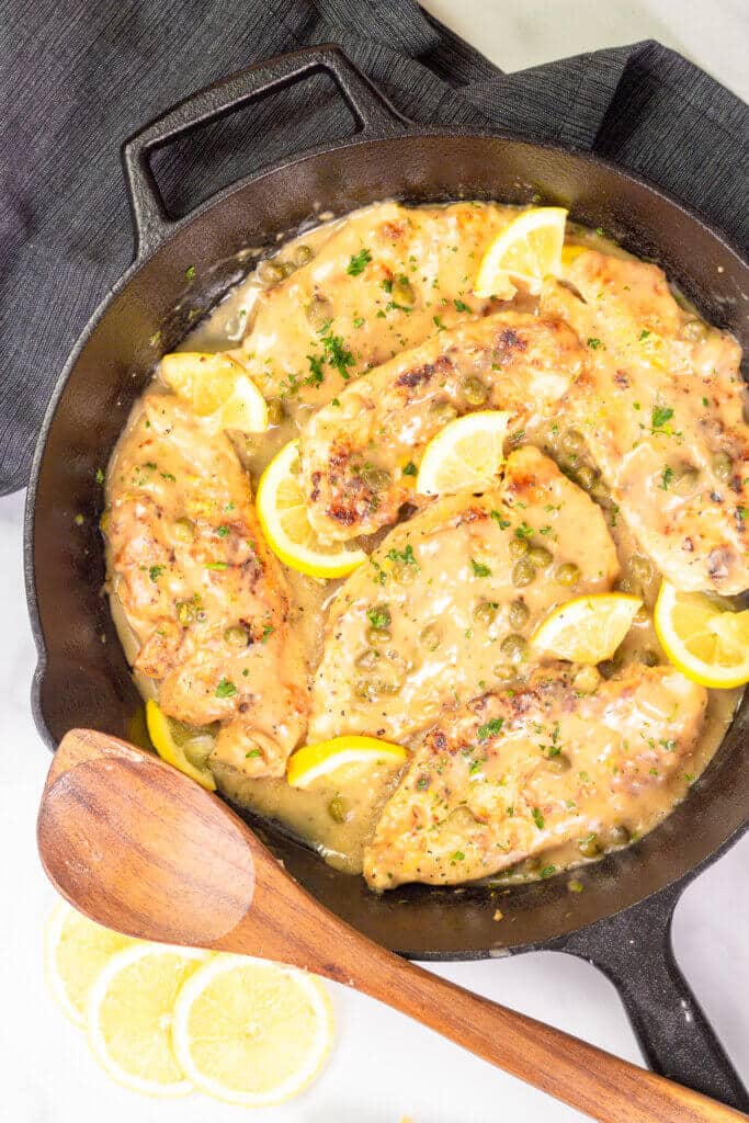 Lemon chicken piccata in a cast iron serving dish.