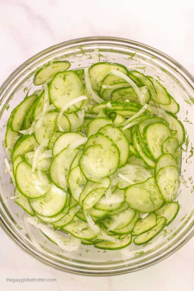 A bowl of cucumber salad ready to be chilled.