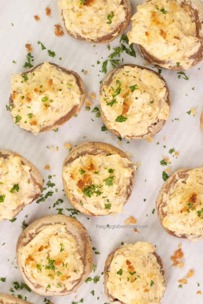 A bunch of stuffed mushrooms fresh from the oven garnished with parsley.