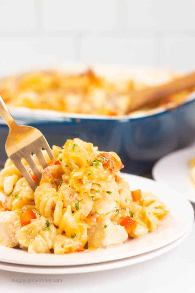 A fork digging into a plate of chicken bacon ranch pasta bake.