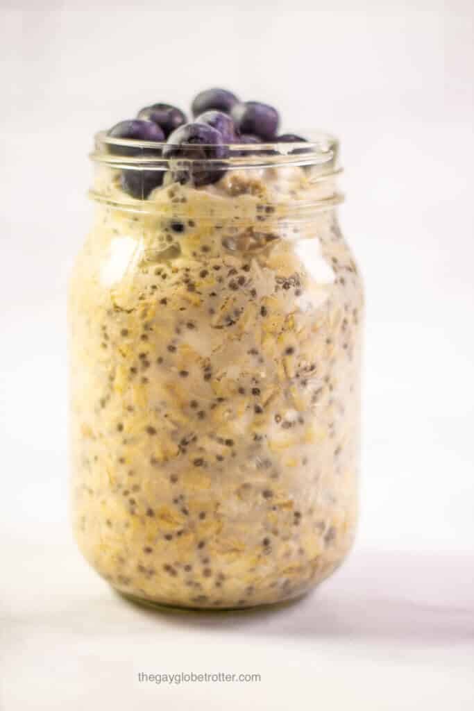 A jar of blueberry overnight oats topped with fresh blueberries.