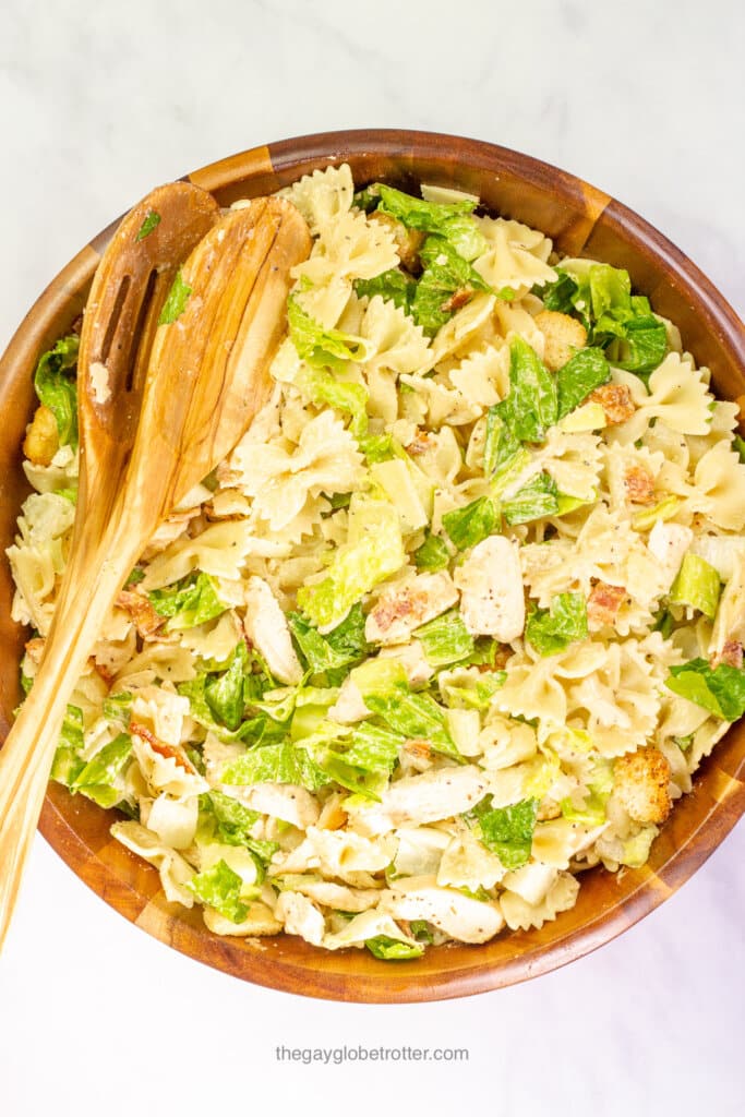 Chicken caesar pasta salad in a wooden serving bowl.