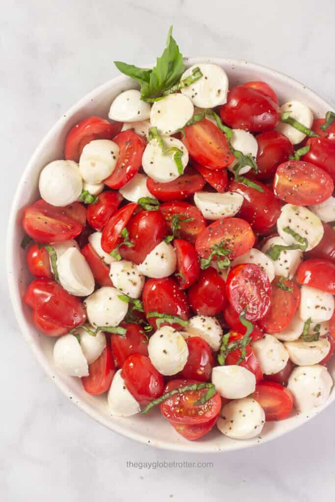 Cherry tomato caprese salad garnished with fresh basil.