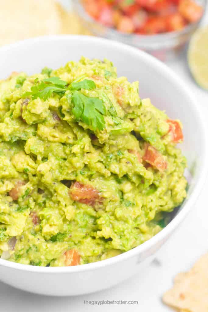 A bowl of fresh homemade guacamole garnished with cilantro.