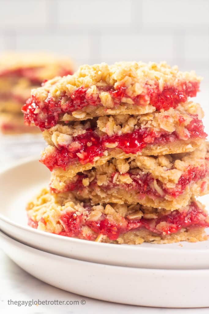 Raspberry oatmeal bars stacked on a serving plate.