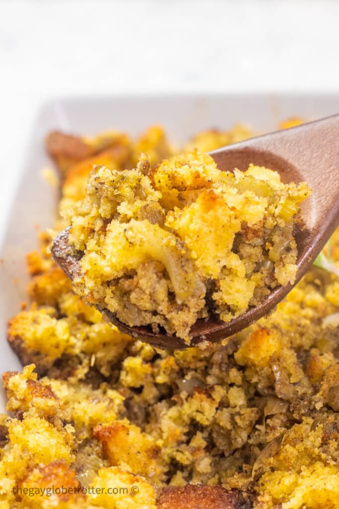 Cornbread stuffing being served on a serving spoon.