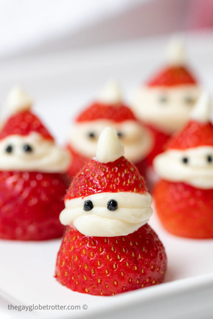 A strawberry Santa on a plate piped with frosting.