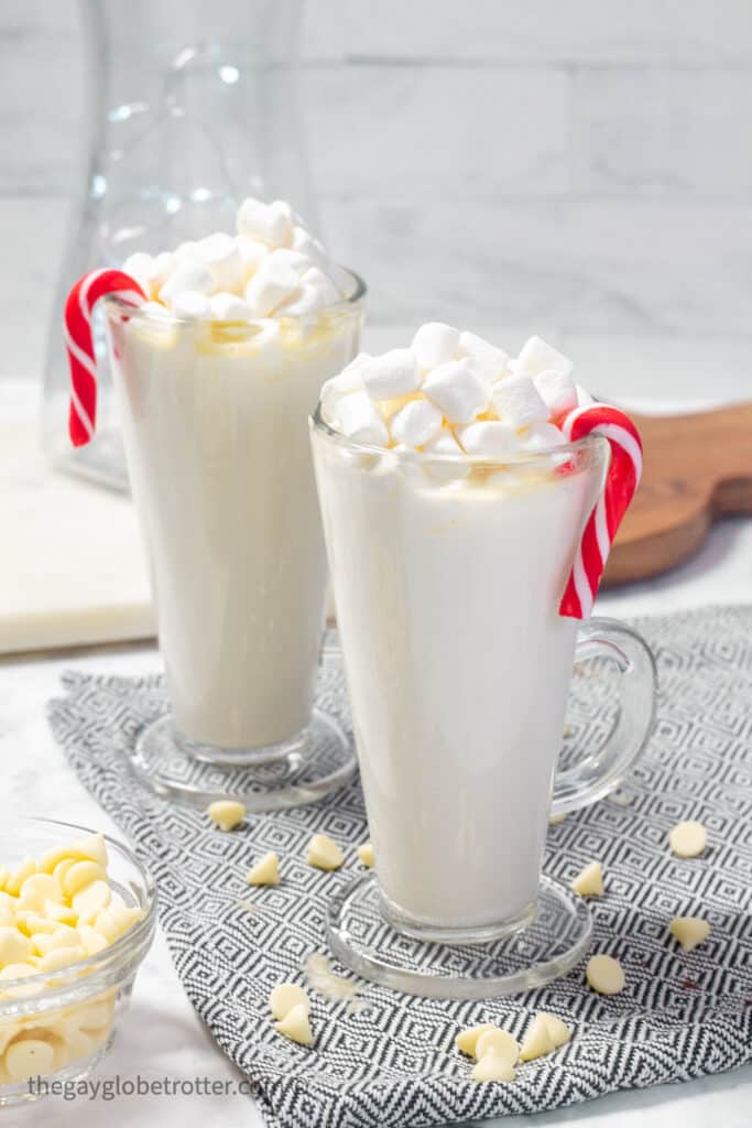Two cups of white hot chocolate with candy canes.