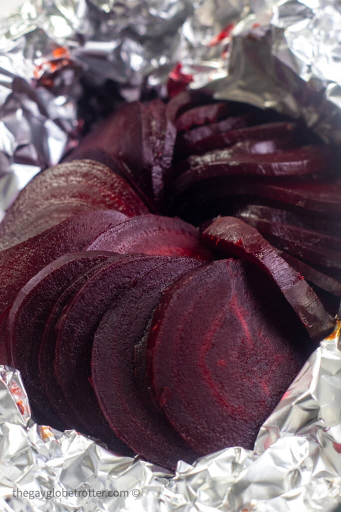 Whole roasted beets in slices in tin foil.