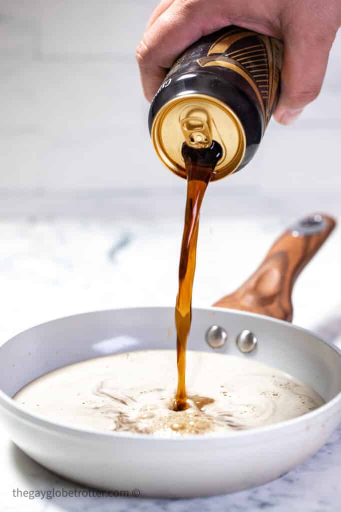 Guinness being poured into a saucepan.