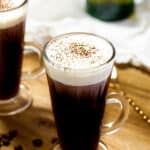 2 cups of Irish coffee next to a stirring spoon.