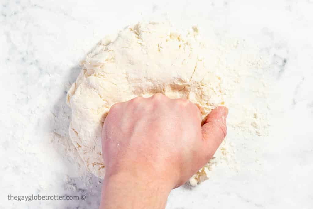 A hand kneading Irish soda bread dough.