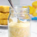 A jar of jiffy corn muffin mix with a spoon and cornbread.