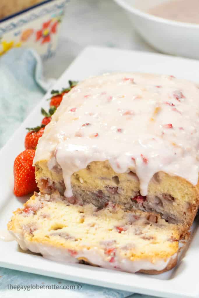 Glazed strawberry bread with a slice removed. 