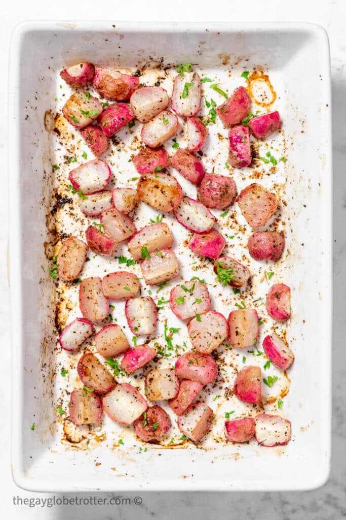 Roasted radishes in a baking dish garnished with parsley.