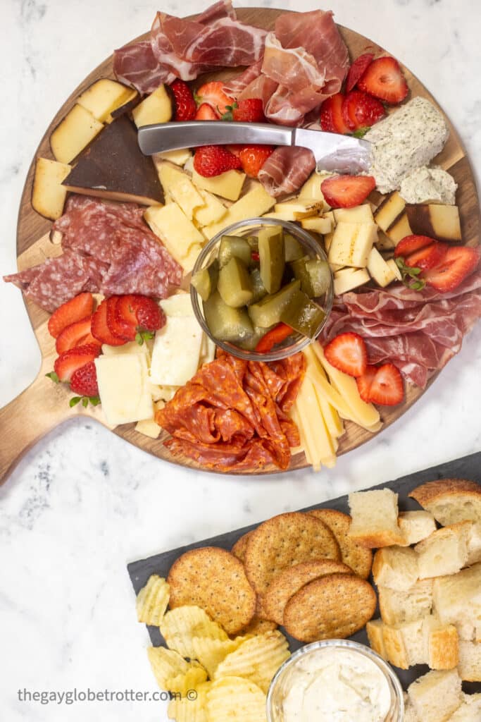 A charcuterie board filled with meat, cheese, berries, and crackers.