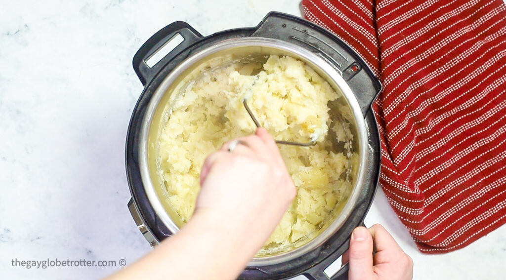 Potatoes being mashed in an Instant Pot.