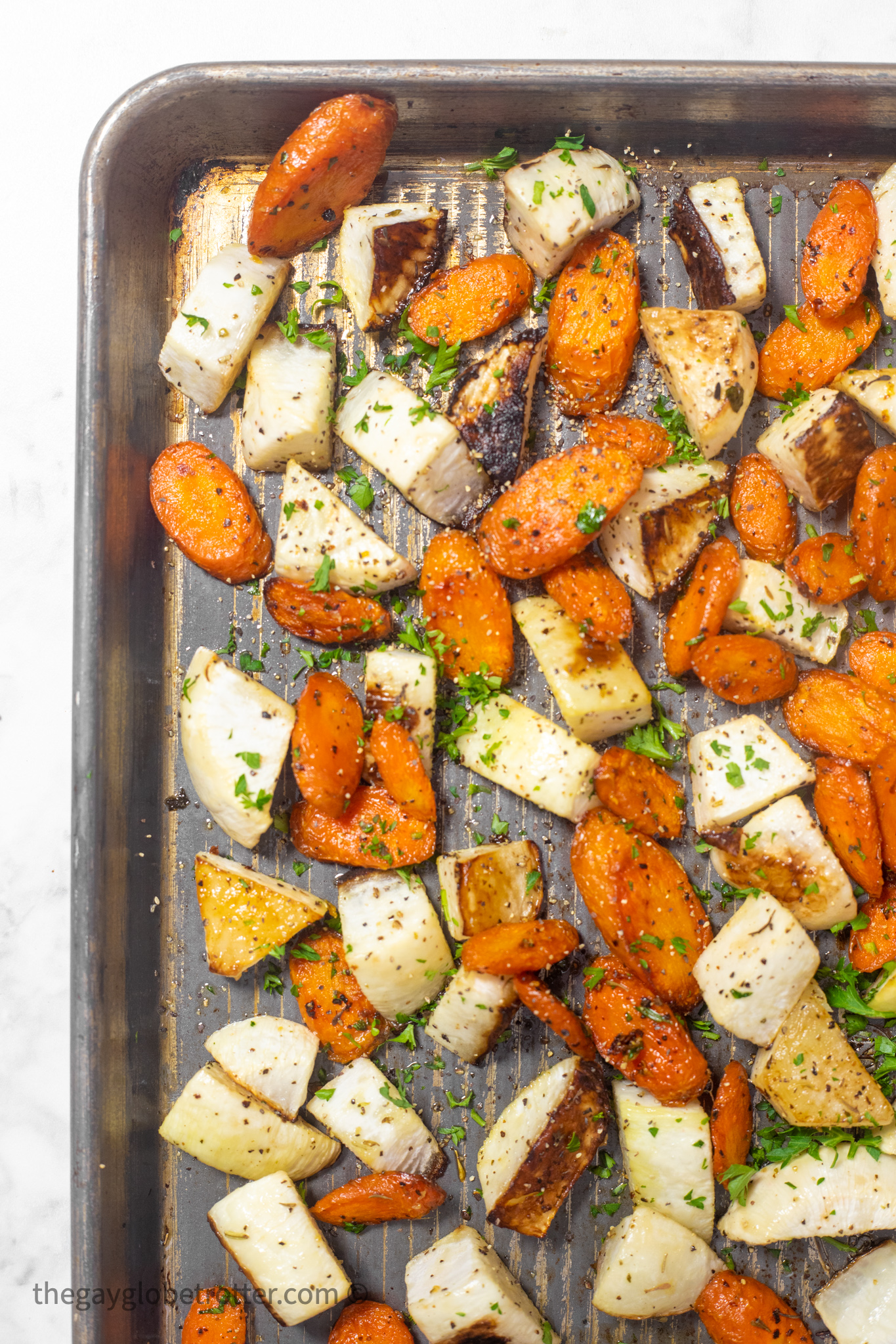 A baking sheet with roasted turnips and carrots.
