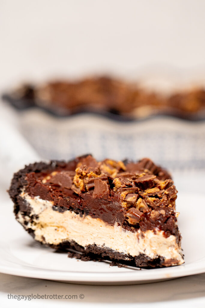 A slice of pie on a plate topped with peanut butter cups.