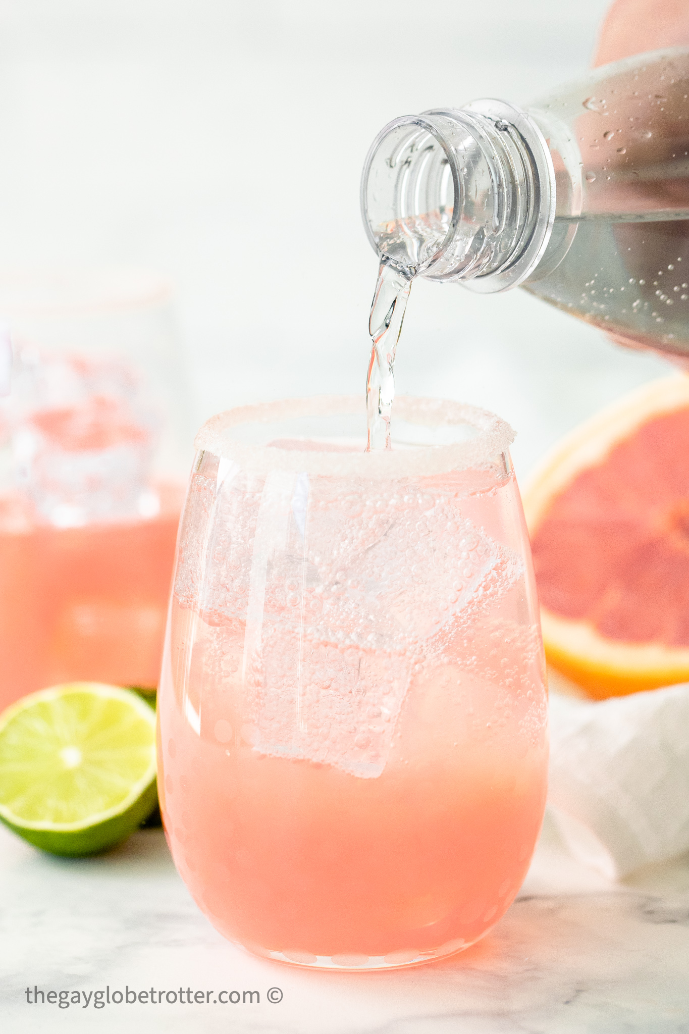 Soda water being poured into a paloma.