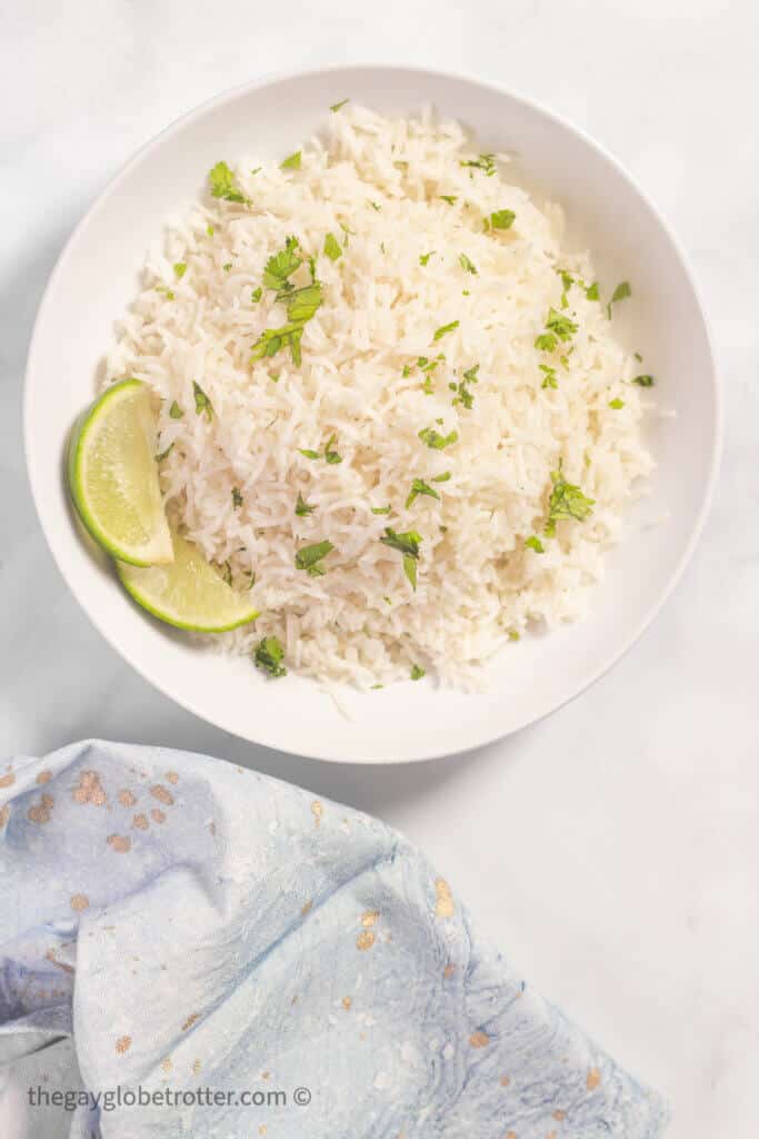 Coconut rice next to a serving napkin and some limes.