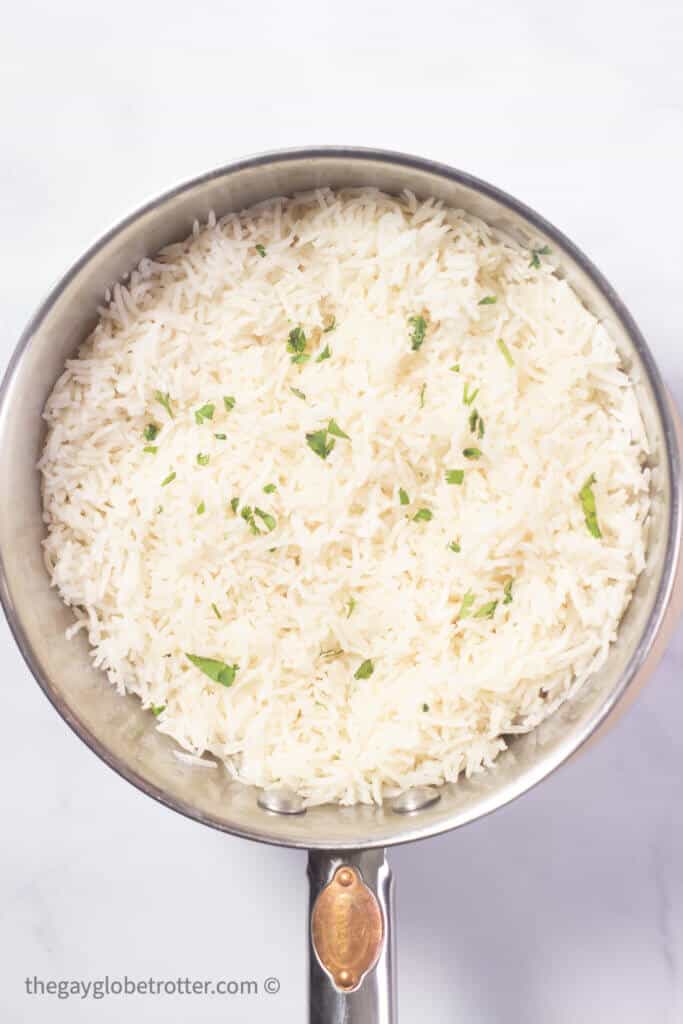 A pot of coconut rice garnished with cilantro.