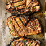 3 pork shoulder steaks on a baking sheet resting.