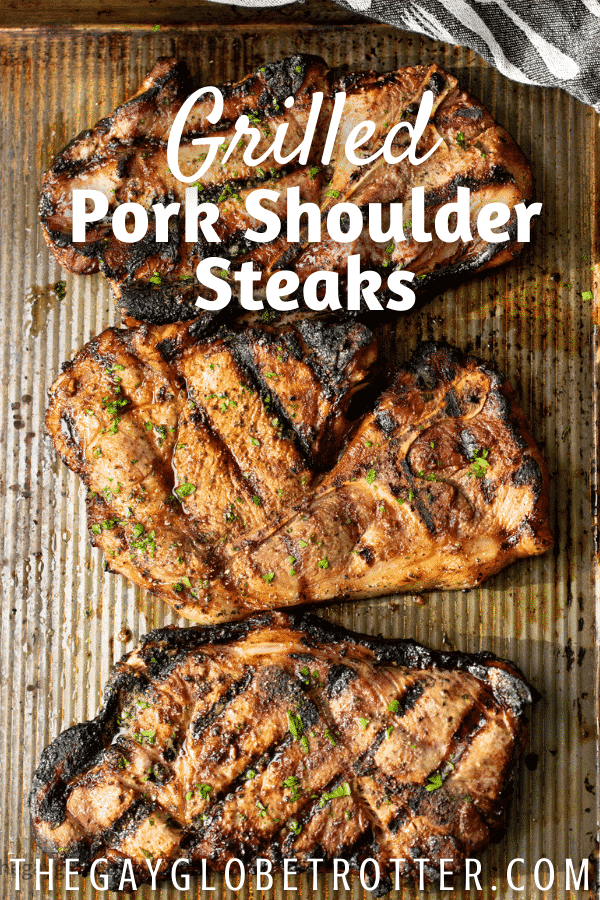Grilled pork shoulder steaks with text overlay.