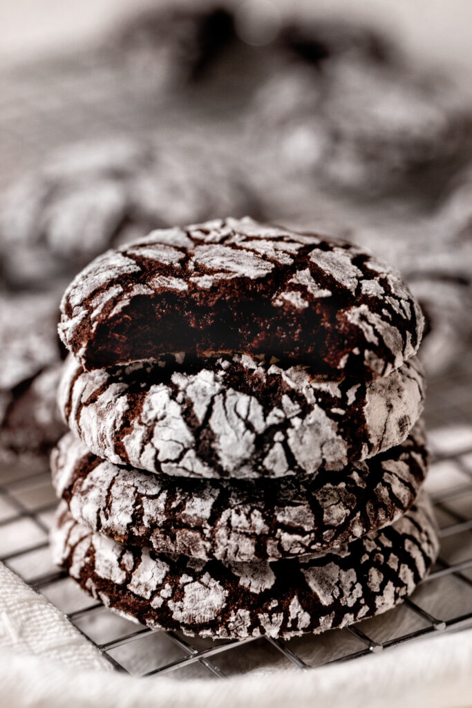 4 chocolate crinkle cookies stacked in a pile.
