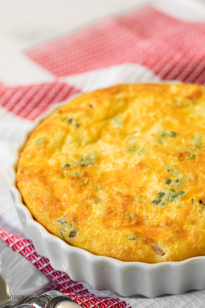 Crustless ham and cheese quiche deflating on a cooling rack.