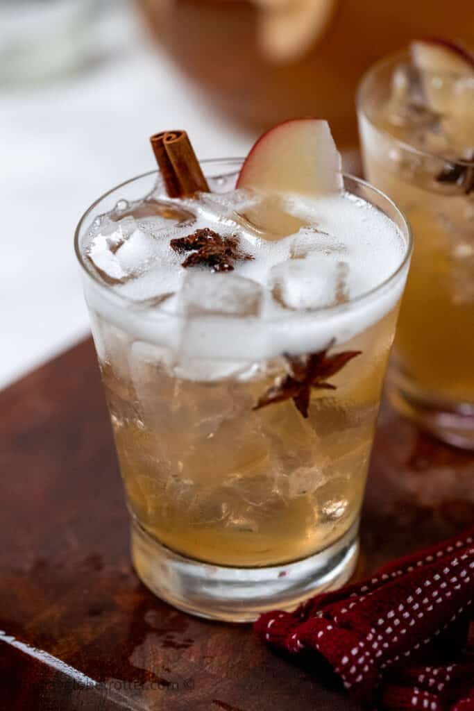 A glass of thanksgiving punch garnished with apples.