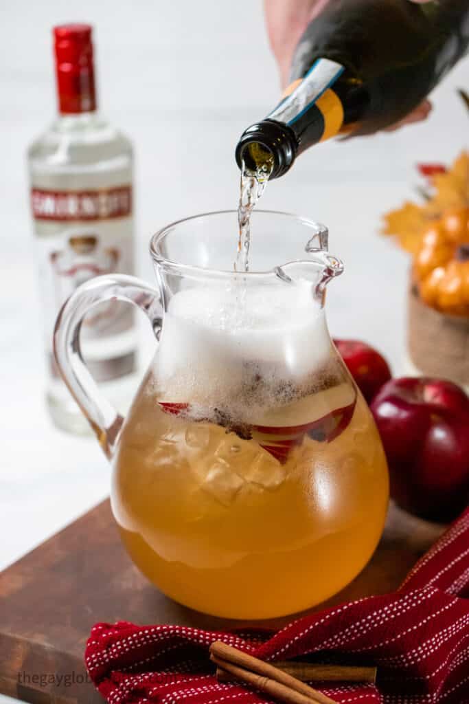 Prosecco being poured into a pitcher.