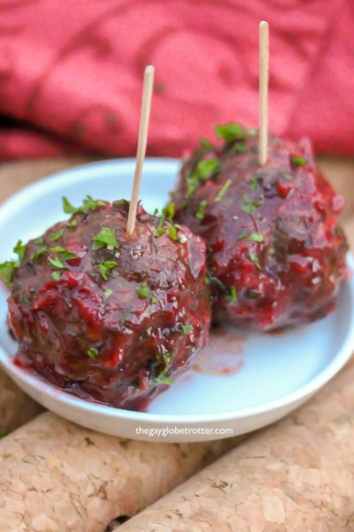 Savoury cranberry meatballs on a white plate.