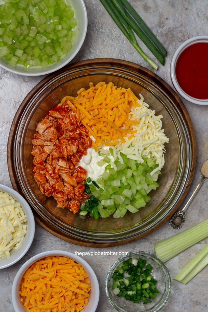 A process shot of buffalo chicken dip ingredients being mixed together.