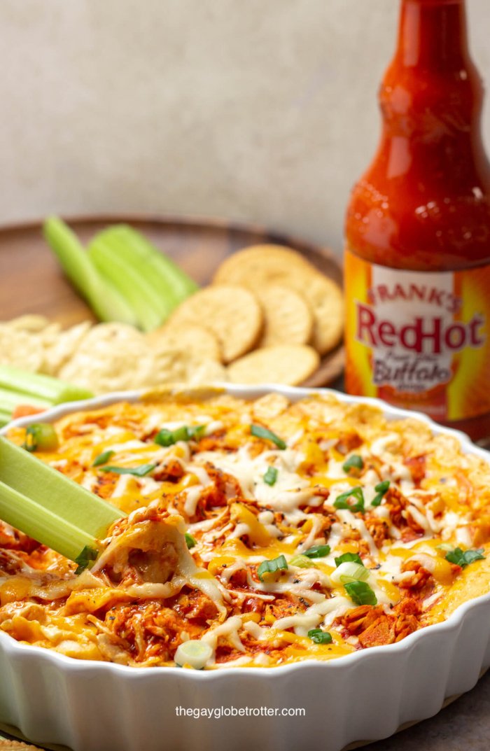 Eine Selleriestange wird in Buffalo Chicken Dip getaucht.