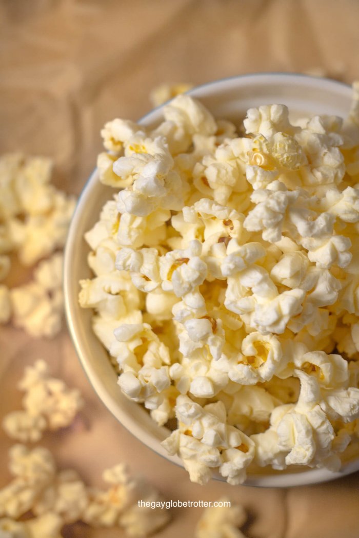 A bowl of kettle corn on a piece of parchment paper.