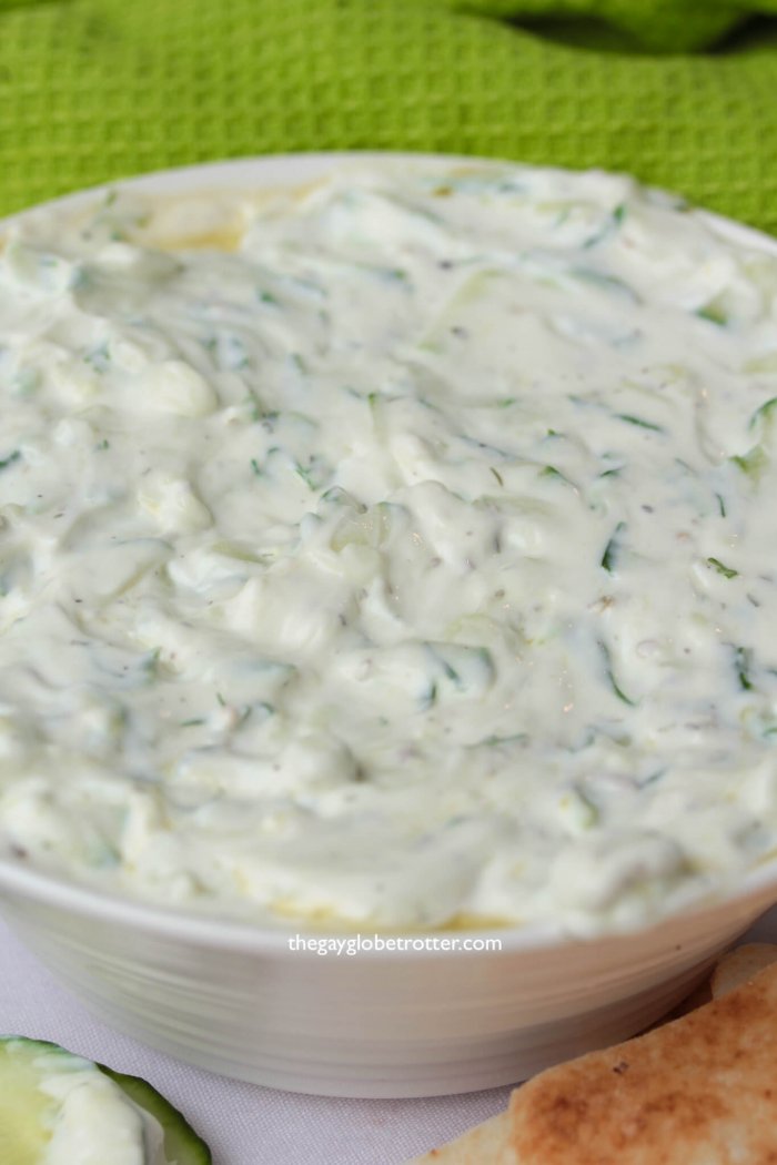 A big bowl of delicious authentic tzatziki with pita and cucumber.