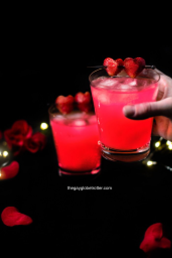 A hand holding a love potion drink with a second one in the background. #gayglobetrotter #lovepotion #lovepotiondrink #lovepotioncocktail #lovecocktail #valentinesday