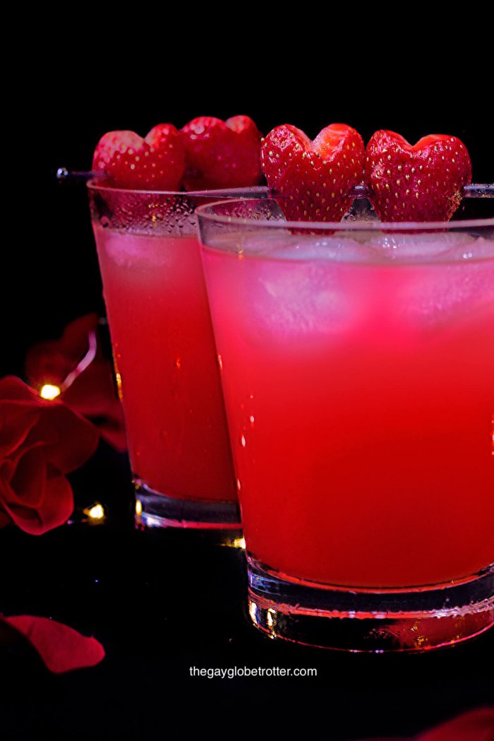 Love potion drinks topped with fresh strawberries surrounded by rose petals.